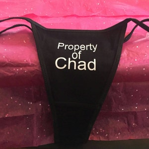 May include: Black lace underwear with the text "Property of Chad" in white.