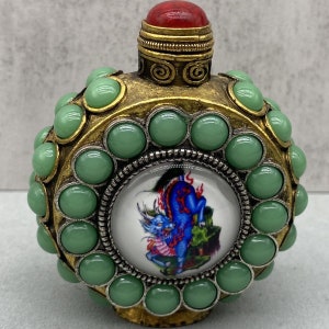 This antique pure copper snuff bottle is inlaid with gems and exquisitely carved by hand.can be collected and used