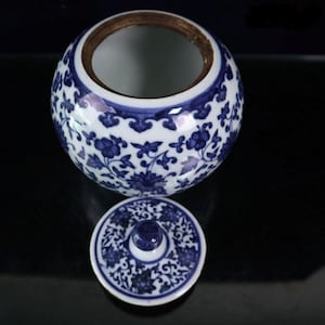 Peut inclure: Un pot en porcelaine blanche avec un motif floral bleu et blanc. Le pot a un couvercle avec un motif assorti. Le pot mesure environ 12,5 cm de haut.