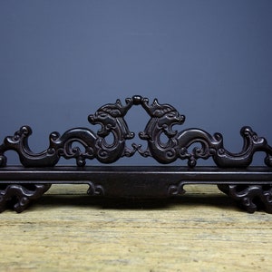May include: A dark wood pen holder with a carved dragon design. The holder is made of dark wood and has a traditional Chinese style.