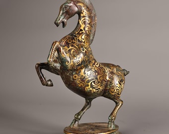 May include: Bronze horse statue rearing up on its hind legs. The horse features detailed gold-coloured patterns across its body and mane. The statue is mounted on a round base with a gold trim, showcasing an artistic design.