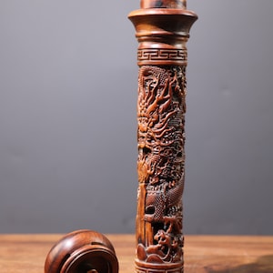 Op de afbeelding: Een houten wierookbrander met een drakenontwerp. De brander is bruin en heeft een deksel. Het deksel is rond en heeft een klein gaatje in het midden.