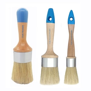 May include: Three paint brushes with natural bristles. Each brush has a wooden handle with a blue top and the text "Chalk Mountain" printed on the handle. The brushes are designed for painting and crafting.