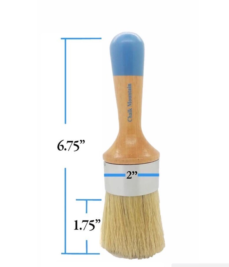 May include: A round paint brush with a light wood handle, a blue painted top, and natural bristles. The brush features a silver metal ferrule and the text Chalk Mountain on the handle. Dimensions are 6.75 inches total length, 2 inches wide, and 1.75 inches for the bristles.