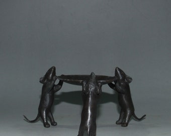 May include: A black bronze sculpture of three mice holding up a circular tray. The mice are standing on all fours and have their tails curled up.