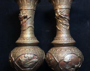 May include: A pair of antique gold and red vases with intricate designs. The vases are decorated with dragons and other mythical creatures.