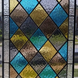 May include: A stained glass window with a diamond pattern in shades of blue, yellow, and gray.