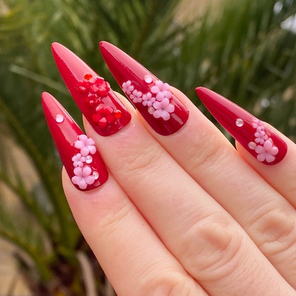 Red fake press-on nails with pink and red flowers cherry blossoms rhinestones long stiletto shape