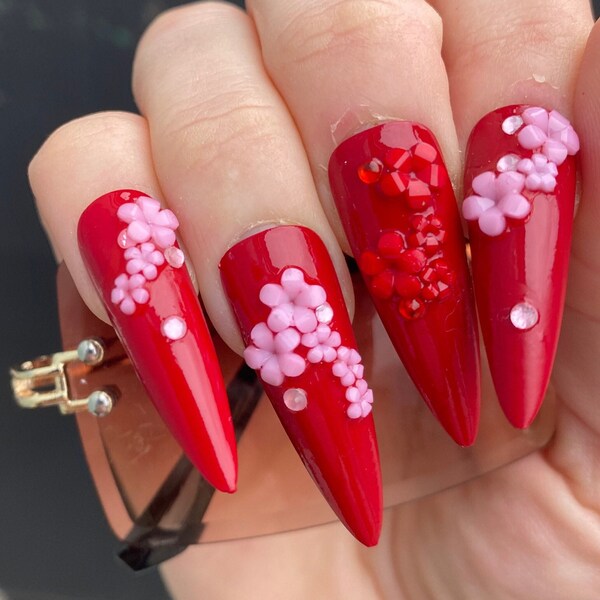 Red fake press-on nails with pink and red flowers cherry blossoms rhinestones long stiletto shape