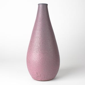 Può includere: Un vaso in ceramica alto, a forma di lacrima, con una superficie testurizzata e macchiata. Il vaso è un gradiente dal rosa chiaro al viola scuro.
