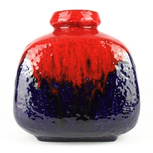 May include: A red and blue ceramic vase with a textured glaze. The vase has a rounded, squat shape with a wide opening.