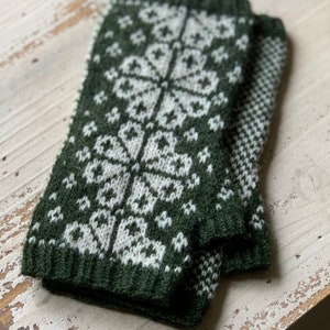 May include: A pair of green and white knitted fingerless gloves with a geometric pattern.