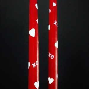 Red taper candles with painted white hearts and pink x's and o's (hugs and kisses)