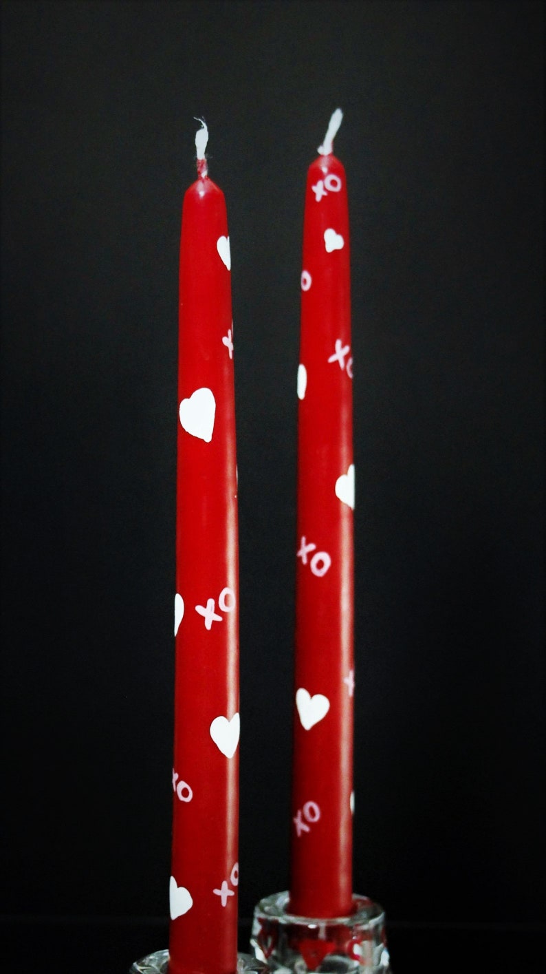 Red taper candles with painted white hearts and pink x's and o's (hugs and kisses)