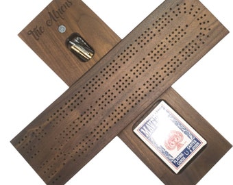 May include: A wooden cribbage board with a personalized inscription "The Allens". The board is open to reveal a deck of playing cards and a compartment for pegs.