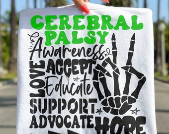 May include: White t-shirt with the words "CEREBRAL PALSY AWARENESS" in green and black lettering. The design includes a skeleton hand making a peace sign, and the words "LOVE, ACCEPT, EDUCATE, SUPPORT, ADVOCATE, HOPE".
