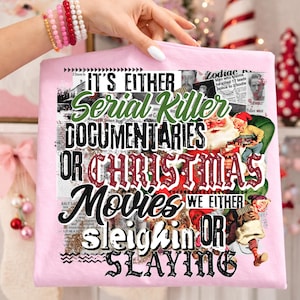 May include: A light pink t-shirt with the text "IT'S EITHER Serial Killer DOCUMENTARIES OR CHRISTMAS Movies WE EITHER sleighin OR SLAYING" in a collage style. The design includes images of Santa Claus and newspaper clippings.