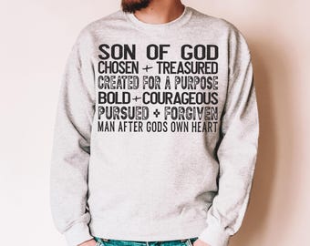 Op de afbeelding: Een grijs sweatshirt met zwarte tekst die "Son of God Chosen + Treasured Created for a Purpose Bold + Courageous Pursued + Forgiven Man After Gods Own Heart" luidt.