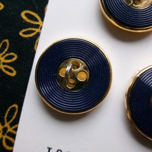 May include: A set of four ceramic coasters with a colorful floral design. Each coaster features a different flower: a red rose, a yellow sunflower, a purple iris, and a blue forget-me-not. The coasters are round and have a cork backing.