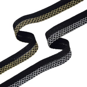 May include: Black elastic trim with a gold and silver metallic pattern. The trim is folded in half, showing both sides.
