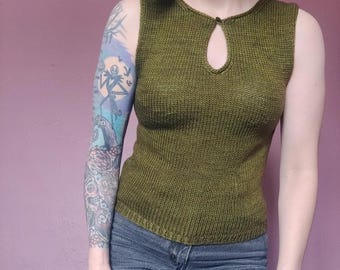 May include: A sleeveless knitted top in a dark green color with a keyhole neckline. The top is made of a soft, textured yarn and has a relaxed fit.