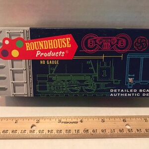 May include: A blue box with the text "ROUNDHOUSE Products" and "HO GAUGE" printed on it. The box features a black and white line drawing of a train engine and a boxcar. The text "DETAILED SCALING AUTHENTIC DESIGN" is printed on the bottom of the box.