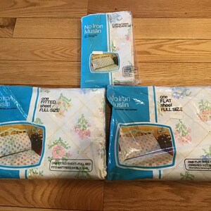 May include: Three packages of No Iron Muslin bedding in full size, including one fitted sheet, one flat sheet, and two standard pillowcases. The packaging features a white fabric with a floral pattern and a yellow diamond grid design.