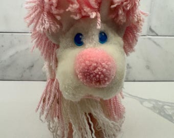 Vintage 1986 Kenner Fluppy Dogs pink and white plush puppy featuring signature yarn hair and bright blue plastic eyes