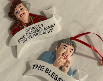 May include: Two Christmas ornaments featuring characters from the movie 'A Christmas Story'. The first ornament features a woman with brown hair and a red and green scarf, with the text 'GRACE? SHE PASSED AWAY 30 YEARS AGO!' The second ornament features a man with brown hair and a blue shirt, with the text 'THE BLESSING!'