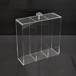 May include: Clear acrylic organizer with four compartments and a crystal knob on the top.