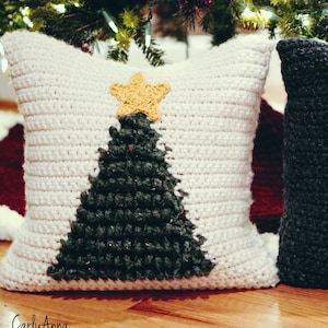 Peut inclure: Deux coussins de Noël en crochet en forme d'arbre de Noël, l'un avec un fond blanc et un arbre vert, l'autre avec un fond noir et un arbre blanc. Les deux coussins ont une étoile jaune au sommet de l'arbre.