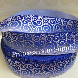 May include: Blue ribbon with a silver swirl design. The ribbon has a gradient effect, transitioning from a lighter blue to a darker blue. The text "Princess Bow Supply" is printed on the ribbon.