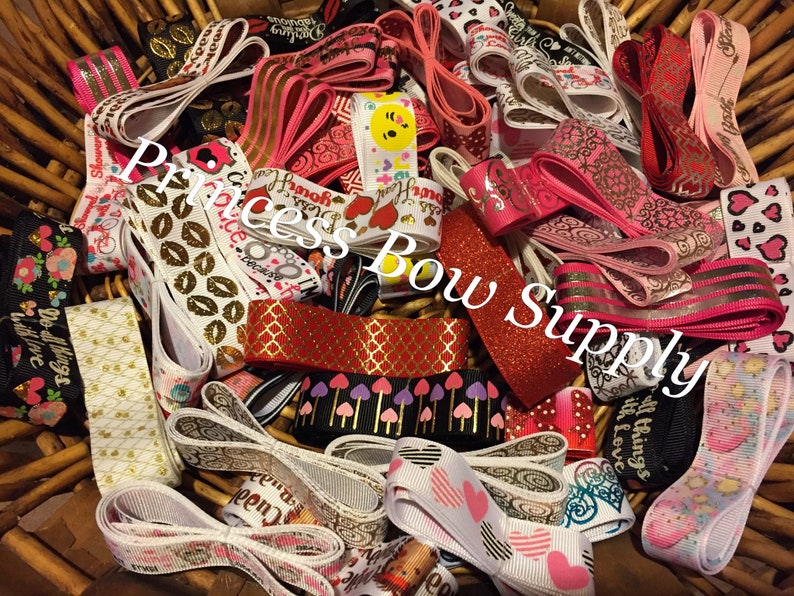 Pu&ograve; includere: Un cesto traboccante di vari nastri in una gamma di colori e motivi. I disegni includono cuori, floreali, geometrici e testo. I nastri sono nelle tonalit&agrave; di rosa, rosso, oro, nero e bianco. Il testo "Princess Bow Supply" &egrave; visibile.