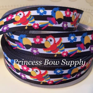 May include: Black grosgrain ribbon with a repeating pattern of colorful parrots, flowers, and white stripes. The ribbon is rolled up, showing the design. The text "Princess Bow Supply" is printed on the ribbon.