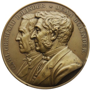 May include: A bronze medal with the text "CARL GERRARD BOLINDER * JEAN BOLINDER." The medal features two men's profiles facing right.
