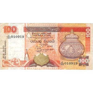 May include: A Sri Lankan 100 Rupee banknote featuring a traditional Sri Lankan pot with intricate designs. The banknote is dated 1995-11-15 and has the text "Central Bank of Sri Lanka" and "One Hundred Rupees" printed on it.