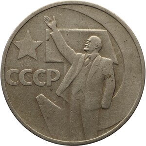 May include: A silver coin featuring a portrait of a man with his arm raised, along with the text "CCCP" and a star on the left.