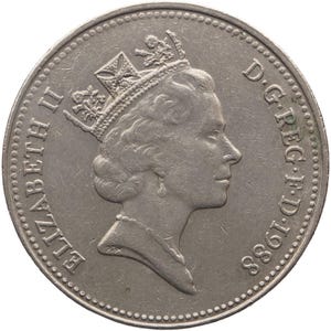 Puede incluir: Una moneda plateada que presenta un perfil de una cabeza coronada, con las inscripciones "ELIZABETH II" y "D.G.REG.F.D. 1988" alrededor del borde. La moneda tiene un diseño detallado y una superficie texturizada.