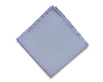Può includere: Un fazzoletto di stoffa quadrato di colore azzurro con un bordo bianco.