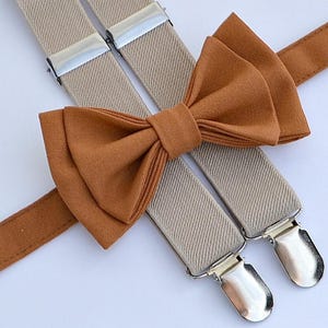 May include: A set of beige suspenders with silver clips and a matching brown bow tie.