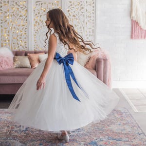 Girl twirling in a white navy beaded dress