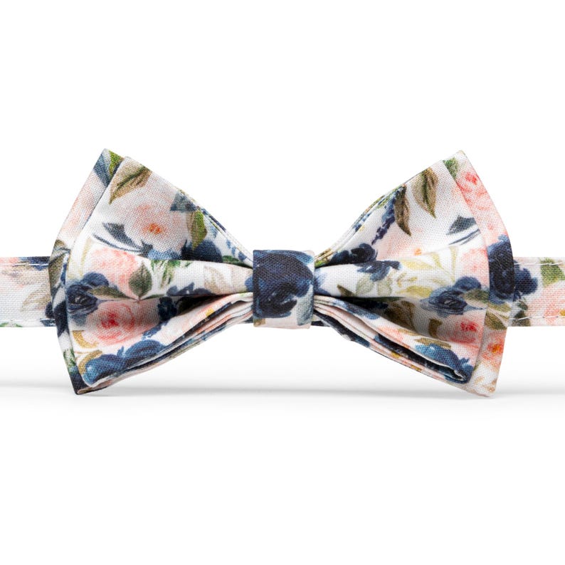 K&ouml;nnte beinhalten: Ein wei&szlig;er Fliege mit einem Blumenmuster mit rosa und blauen Blumen.