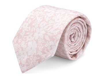 May include: A pink patterned tie with a white floral design. The tie is rolled up and ready to be worn.