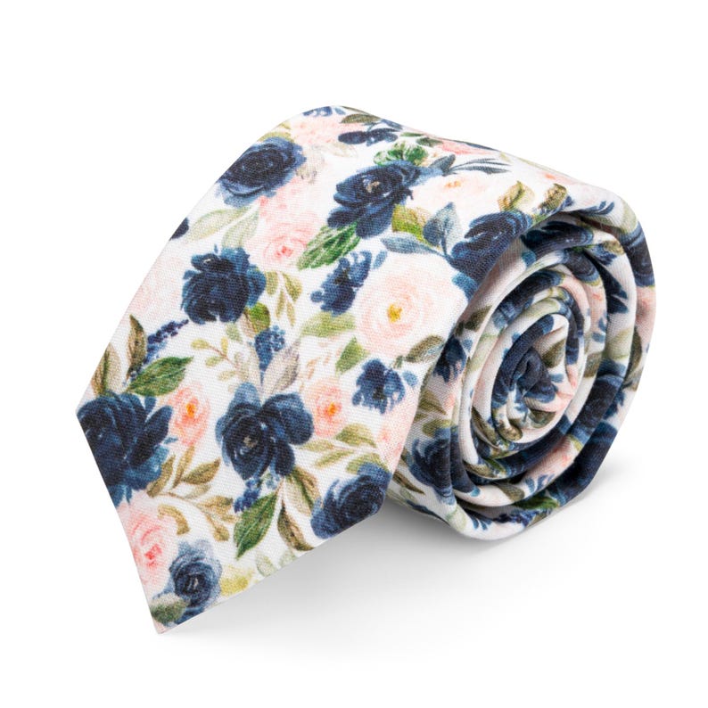 K&ouml;nnte beinhalten: Eine wei&szlig;e Krawatte mit einem Blumenmuster mit dunkelblauen und rosa Bl&uuml;ten.