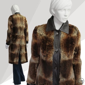 May include: A long brown faux fur coat with a black leather collar and button fastening. The coat has a chequered pattern and is lined with a brown fabric.