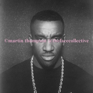 May include: Black and white photograph of a person wearing a black shirt and a thick gold chain necklace. The photo is captioned "©martin thompson @thefacecollective".