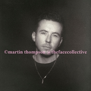 May include: A black and white portrait of a person wearing a black shirt with a silver chain necklace. The text "©martin thompson @thefacecollective" is at the bottom of the image.