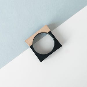 Svart fyrkantig ring med trä
