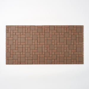 May include: A rectangular mosaic tile panel with a repeating pattern of various sized brown and reddish-brown rectangular tiles. The tiles are arranged in a seemingly random, yet structured, design. The panel is set against a white background.