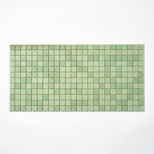 May include: A rectangular mosaic tile sheet composed of small, square tiles in a muted green hue. Some tiles have a speckled, textured appearance. The tiles are arranged in a grid pattern, with thin, light-colored grout lines separating them.